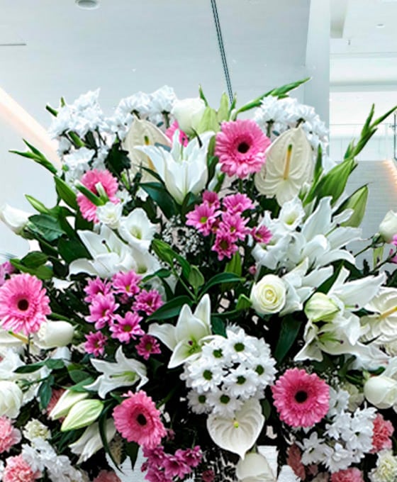Corona con flores blancas y rosadas para enviar
